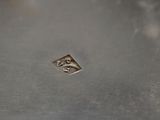 a close up of a silver plate with a diamond on it