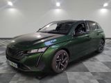 La voiture verte est garée sur un sol à damier, dans une pièce.