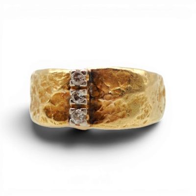 une image montrant un gros plan d'une bague en or sertie de diamants