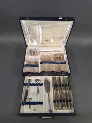 un service d'argenterie dans un coffret bleu posé sur une table
