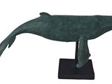 sculpture of a green whale on a black base