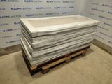 une pile de draps blancs posée sur une palette dans une pièce