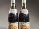 two bottles of wine sitting on top of a table next to each other