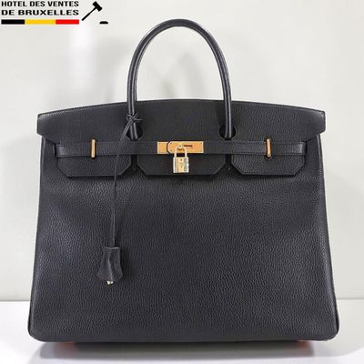 un sac à main en cuir noir orné d'un fermoir doré