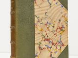 an old book with a green cover and a floral design on it