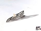 a small white pearl on a silver plated brooch
