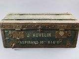 an old wooden trunk with a sign on the side of it