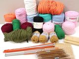 yarn, crochets, knitting needles, and knitting needles on a table
