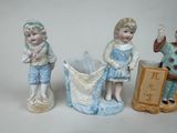 three figurines of children standing next to each other