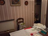 a bedroom with a bed, dresser, mirror and pictures on the wall
