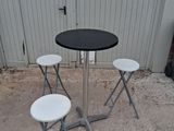 three stools and a table in front of a building