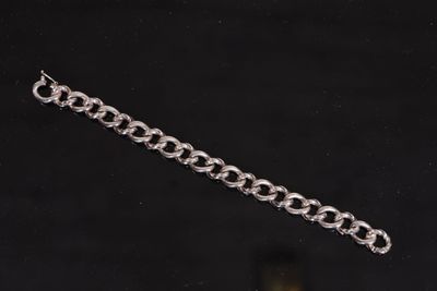 a close up of a silver chain bracelet on a black background