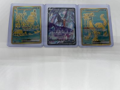 three different pokemon trading cards in plastic cases on a white surface