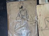 some drawings and pictures of a woman in a dress on a table