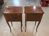 pair of antique side tables in a store with bottles of wine in the background
