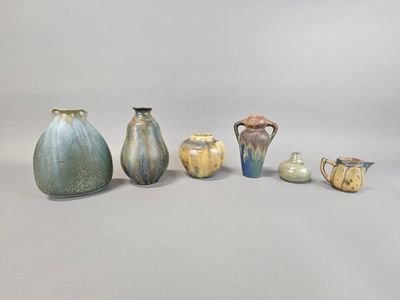 many different vases and cups sitting on a white surface