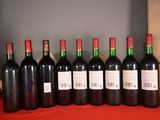 six bottles of red wine are lined up on a table