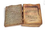 an old book with chinese writing is open on a white surface