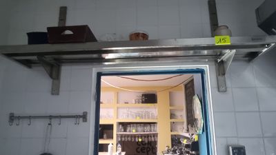 a door that is open in a kitchen with a shelf above it