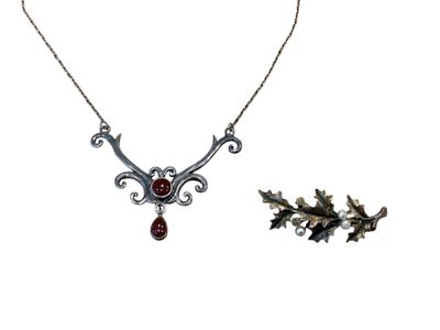 une image représentant un collier et une broche sur fond blanc