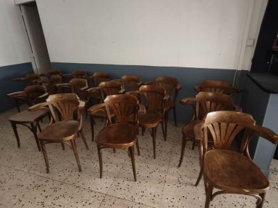 de nombreuses chaises en bois dans une pièce aux murs bleus