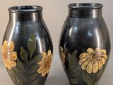 two black vases with yellow flowers painted on them