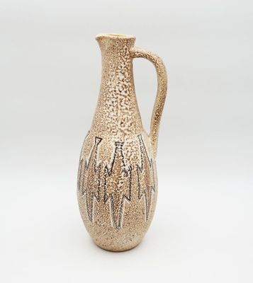 a small vase with a handle on a white surface