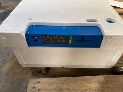 une boîte blanche surmontée d'une horloge numérique bleue
