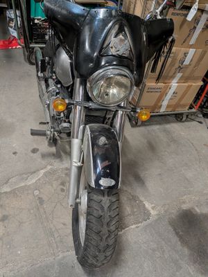 a motorcycle that is parked in a garage with boxes on the back