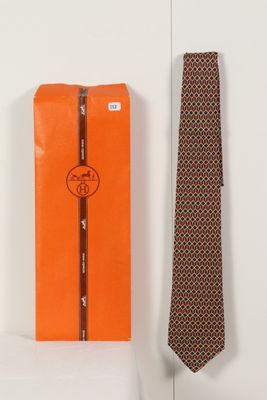 une boîte orange ornée d'une cravate, à côté d'une cravate orange