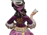 figurine of a woman in a purple dress holding a book