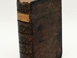 an old book sitting on top of a table next to a white background