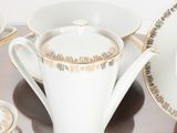 a table with a plate, cups, and saucers on it