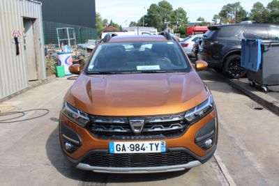 a orange car parked in a parking lot with other cars in the background
