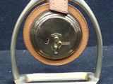 a silver clock with a brown leather band on a stand