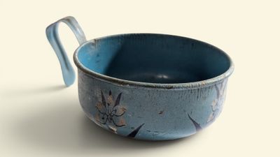 un bol bleu muni d'une anse, posé sur une table