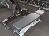 a gym room with a bench, weights, and a row of dumbs