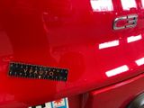 a close up of a red car with a sticker on it