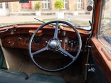 a steering wheel and dashboard of a car in front of a building
