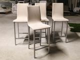 three white chairs sitting on top of a cement floor next to a pile of trash