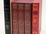 three books are stacked on top of each other on a white surface