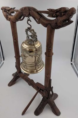 une cloche posée sur un support devant un miroir