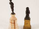 two statues of a man and a woman on a pedestal