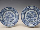 pair of blue and white plates with flowers and birds on them