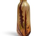 grand vase en verre orné de motifs marron et verts sur fond blanc