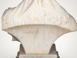 an antique marble bust of a woman with a shawl on her head