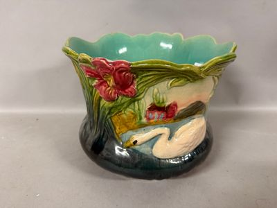 a ceramic vase with a swan and flowers on it