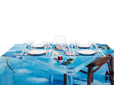 une table recouverte d'une nappe bleue sur laquelle est représenté un bateau