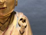 a gold statue of a person with his eyes closed