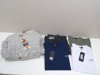 un grand nombre de t-shirts posés sur une table